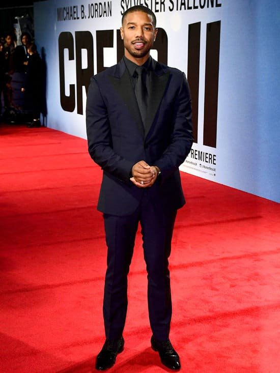 black suit red carpet Michael B. Jordan in a tailored black suit on the red carpet at the Creed II premiere, wearing a clean low fade and subtle beard