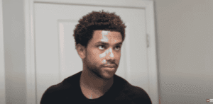 4C curls hairstyle Black man with a fresh haircut and 4C curls looking sideways in a bathroom