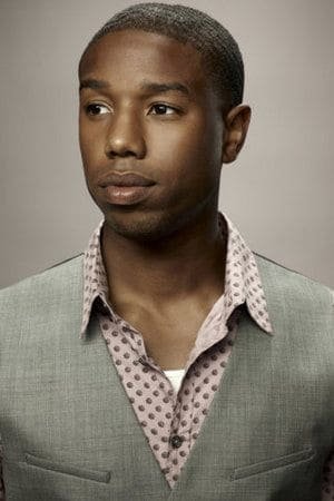 Young MBJ in Classic Taper Young Michael B. Jordan wearing a light gray suit with a patterned shirt and a low classic taper haircut