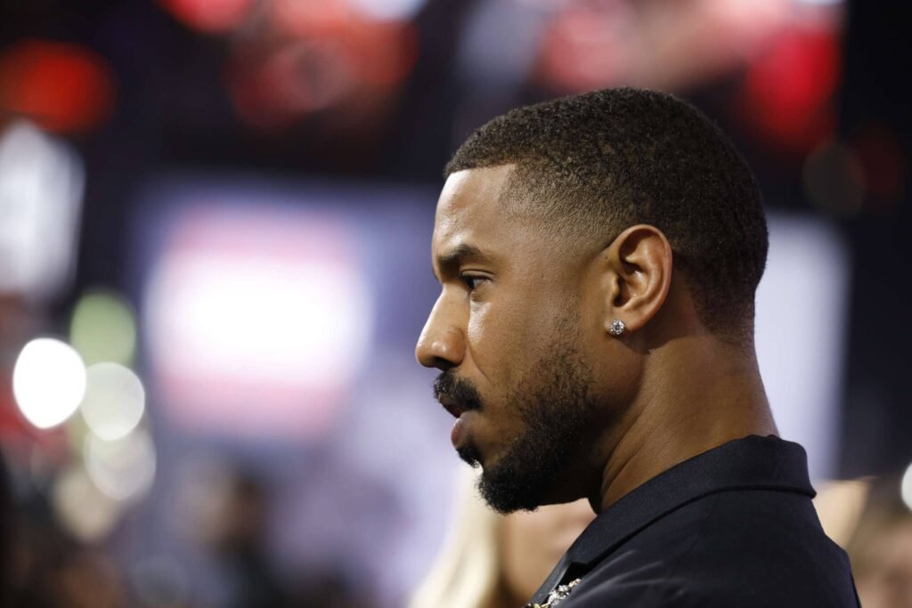 low taper fade Side profile of Michael B. Jordan with a clean low taper fade haircut, showcasing sharp grooming and natural texture