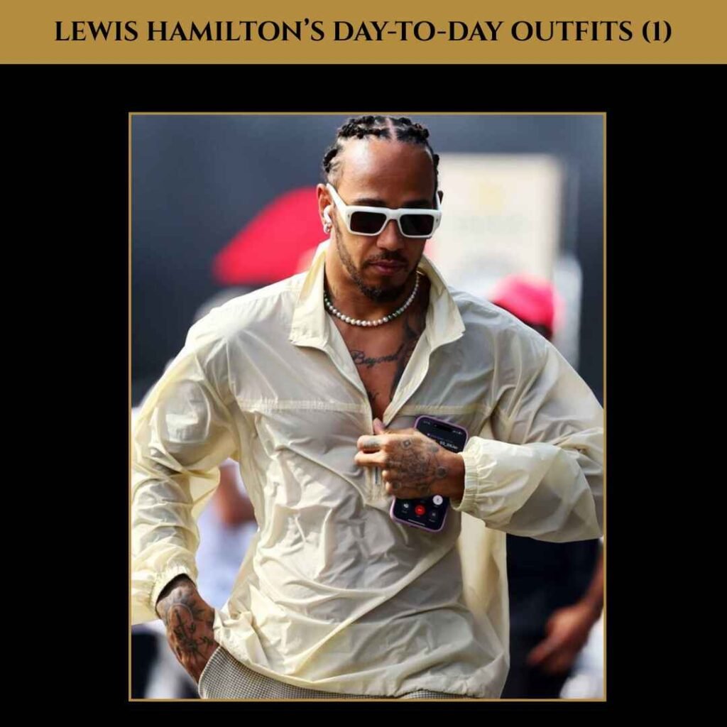 Lewis Hamilton Day-to-Day Outfits Lewis Hamilton wearing a cream button-down shirt with layered chains and sunglasses, showcasing his casual day-to-day style.