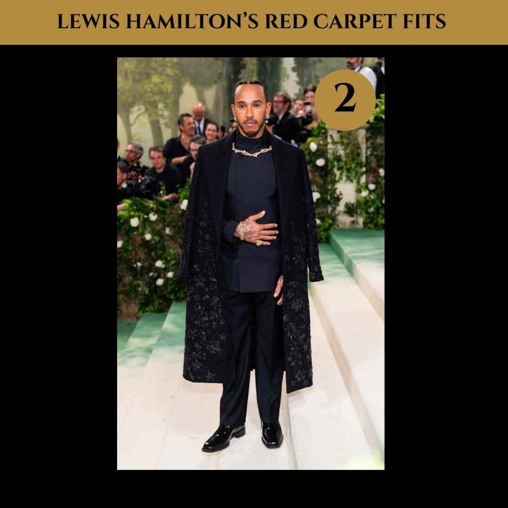 lewis-hamilton-red-carpet-fits (2) Lewis Hamilton on the red carpet wearing a black high-neck suit jacket with wide-leg pants and a long embroidered overcoat at the 2024 Met Gala.