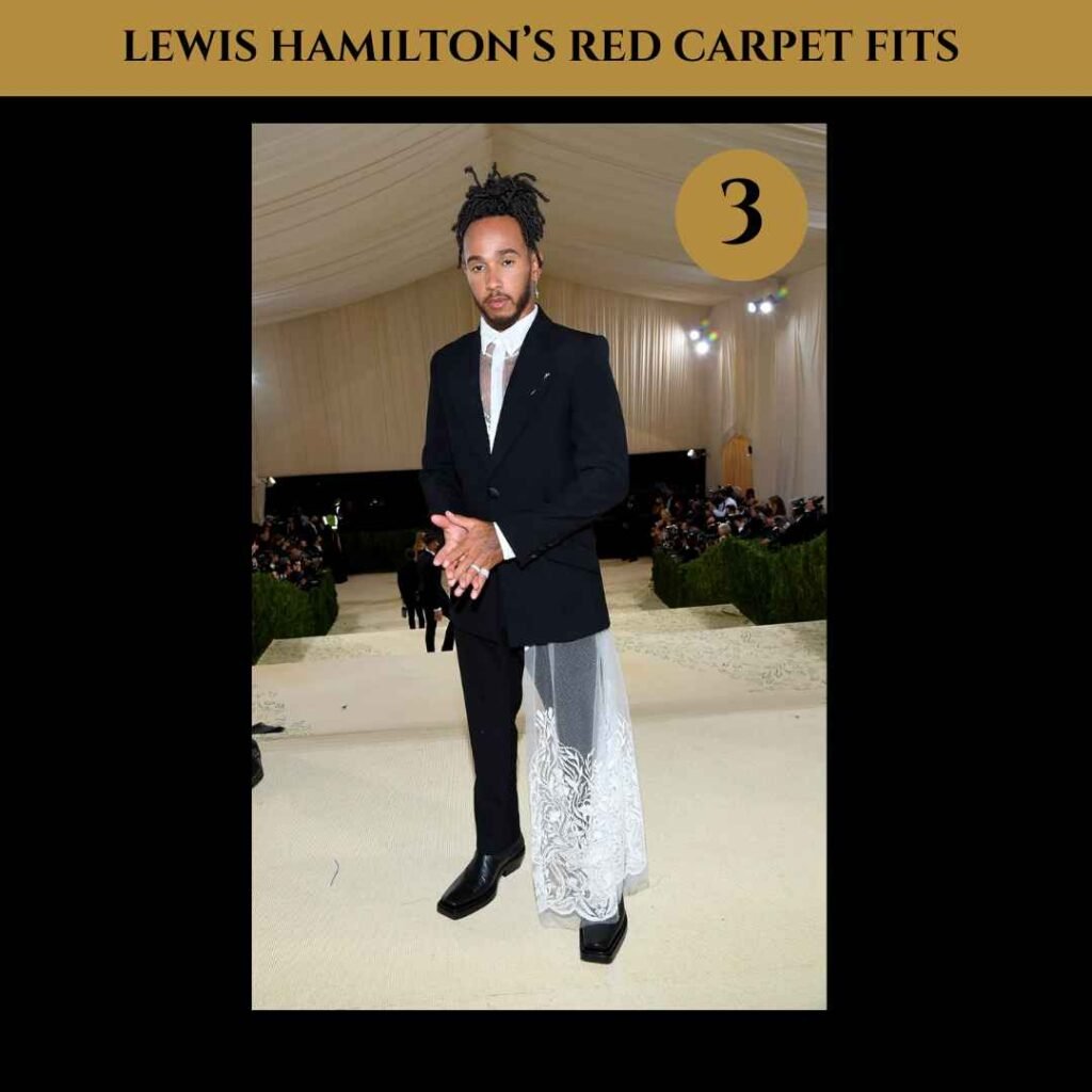 lewis-hamilton-red-carpet-fits (3) Lewis Hamilton in a black tailored suit at the 2021 Met Gala, styled with a see-through white lace shirt and a lace train.
