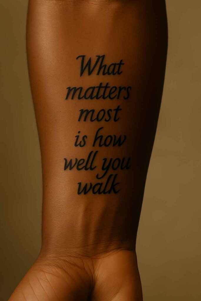 Two-line quote forearm tattoo for Black men Black man’s forearm tattoo featuring a two-line inspirational quote in script