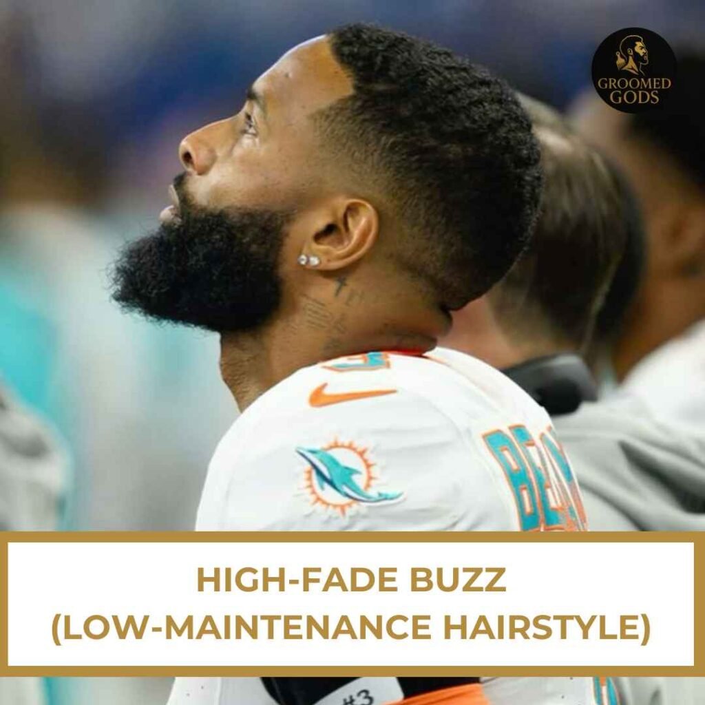 Black man with a high fade buzz cut, viewed from the side, wearing a Miami Dolphins jersey.