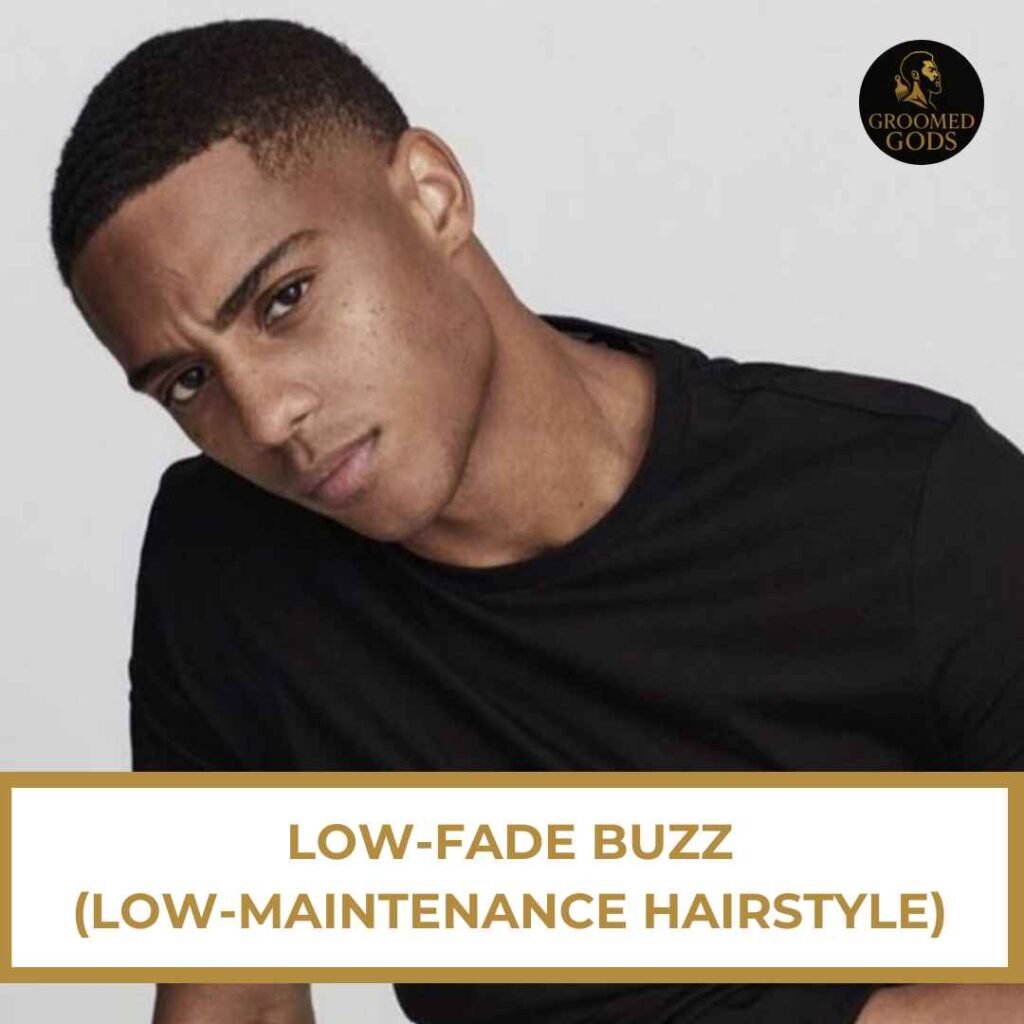 Young Black man with a low fade buzz cut, wearing a black crewneck shirt and tilting his head slightly.