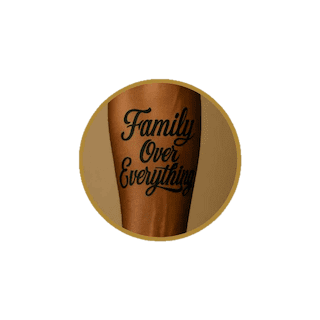 Script and lettering forearm tattoo reading “Family Over Everything” on brown skin.